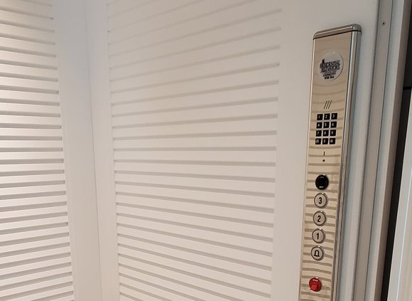 Elevator interior with silver control panel